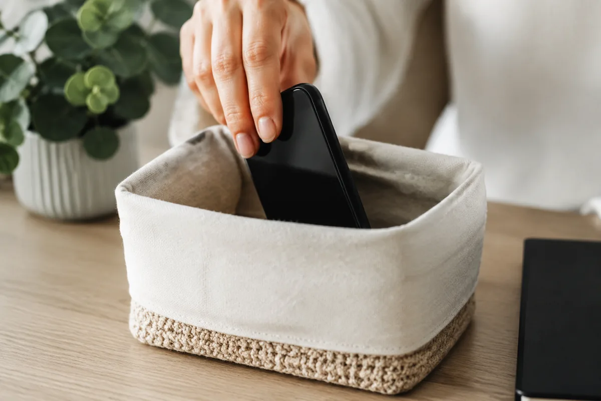 Les bienfaits de la détox digitale pour retrouver ton énergie Mains tenant une tasse de thé fumante sur une table en bois, sans aucun écran visible aux alentours