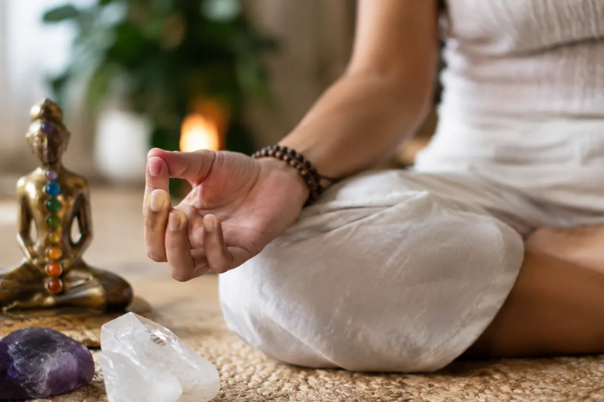 Dangers de la kundalini : mon guide pour avancer sereinement Gros plan sur les mains posées sur les genoux en posture de méditation sereine