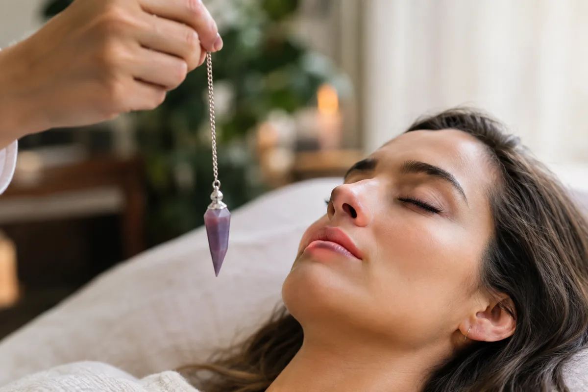 Hypnose régressive : mon voyage au cœur des mémoires de l'âme Un carnet intime ouvert sur une table en bois avec une plume et un cristal de quartz fumé